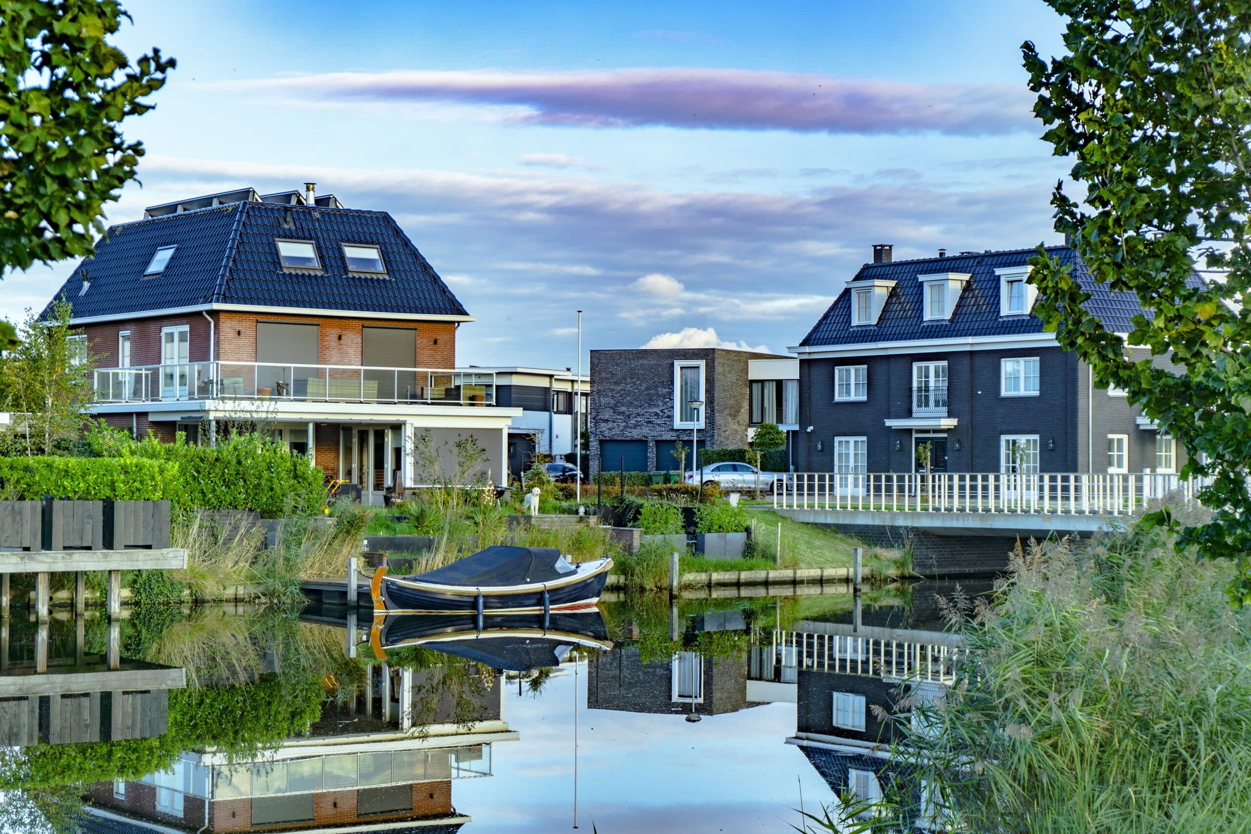 Rijtjes woningen in Almere met sloep voor de deur in het water